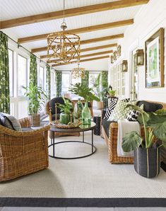 a living room with wicker furniture and plants in vases on the coffee table