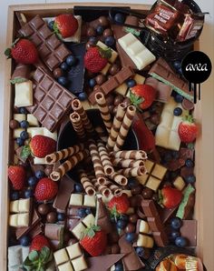 a box filled with lots of different types of chocolates and strawberries on top of it