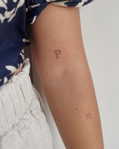 a woman's arm with a small tattoo on the left side of her arm