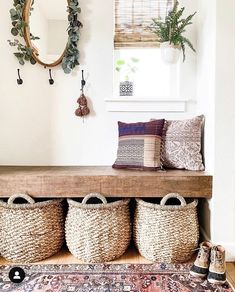 a bench with baskets on it in front of a mirror