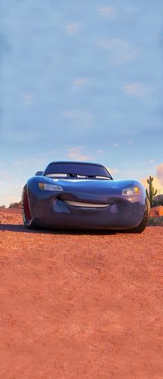 a blue car sitting on top of a dirt field