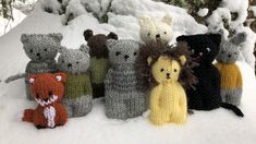 knitted stuffed animals are lined up in the snow