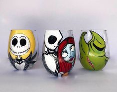 three wine glasses with painted designs on them, one has a skeleton and the other has a ghost