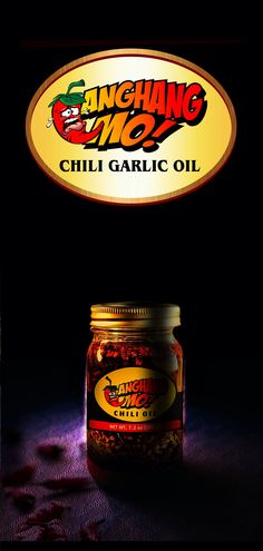 a jar of chili garlic oil sitting on top of a table next to a sign