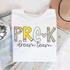 Pre-K Teacher Shirt, Pre-K Dream Team Tshirt, Pre-K Squad, Preschool Crew, PreK Teacher Shirt, Pre-K Teacher Team Shirts, Retro PreK Teacher ABOUT: ⋒ The shirt used is the Bella + Canvas 3001 Unisex Jersey Short Sleeve Tee ⋒ SOLID COLORS: 100% ring-spun cotton HEATHER COLORS: 52% ring-spun cotton & 48% polyester (Athletic Heather & Black Heather are 90% ring-spun cotton & 10 polyester) ⋒ Lightweight fabric - breathable ⋒ Rolled sleeves in pictures is for styling purposes only ⋒ Props used in pho Teacher Shirts Elementary, White Tops For Teacher Appreciation Back To School, White Tops With Name Print For Back To School, White Top With Name Print For Back To School, White Tops With Name Print For School, White Name Print Top For Back To School, White Name Print Top For School, White School Top With Name Print, White Long Sleeve Tops For Back To School