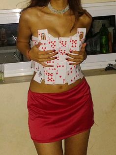 a woman in a red skirt and white shirt with cards on her chest posing for the camera