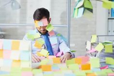 a man sitting at a table covered in sticky notes