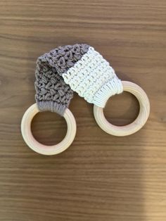 two crocheted knitted baby toys on top of a wooden table