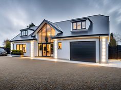 a large house with two garages and lights on the side of it's windows