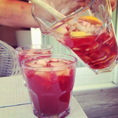 two glasses filled with liquid sitting on top of a table