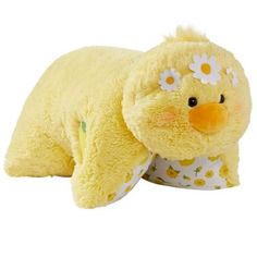 a yellow stuffed animal with daisies on it's head and eyes, laying down