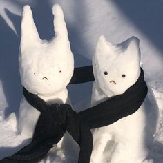 two snowmen wearing scarves and scarfs in the snow