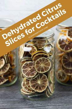 three jars filled with sliced oranges on top of a wooden table