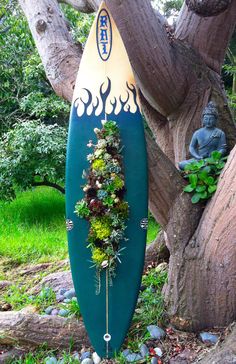 a blue surfboard sitting next to a tree