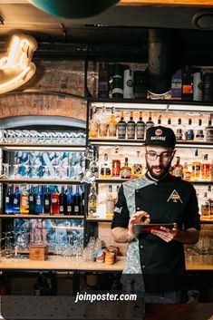 a man standing in front of a bar holding a tablet