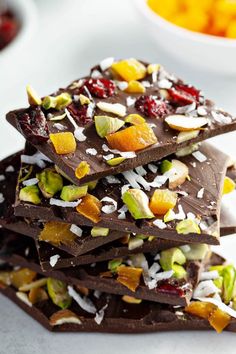 a stack of chocolate bars topped with nuts and dried cranberries