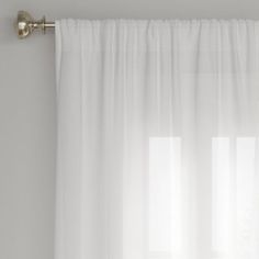 a white curtain hanging on the side of a window