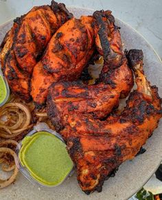 chicken wings and onion rings on a plate with dipping sauce