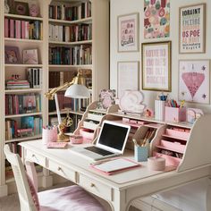 a white desk topped with a laptop computer next to a book shelf filled with books