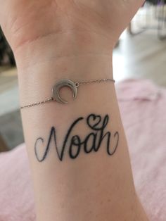 a woman's wrist with the word noah written on it and a crescent in the middle