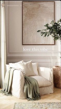 a living room with white furniture and a large painting on the wall that says love this vibe