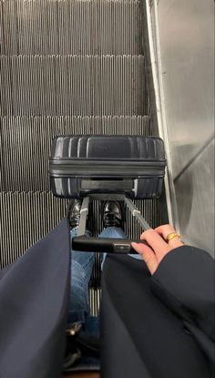 someone is riding an escalator with their hand on the handlebars while using his cell phone