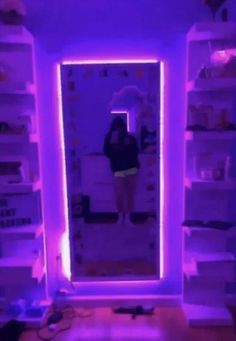 a person standing in front of a mirror with purple light on it's sides