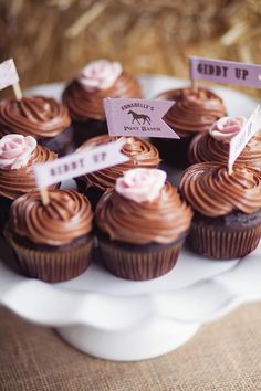 chocolate cupcakes with pink frosting on a white platter, labeled debt up