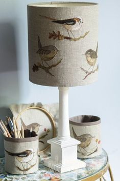 a lamp that is sitting on top of a table next to some pens and pencils