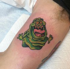 a green cartoon character tattoo on the leg