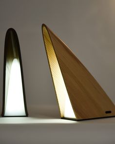 two wooden lamps with one light turned on and the other turned off, sitting side by side