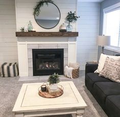 a living room with a couch, coffee table and fire place in the middle of it