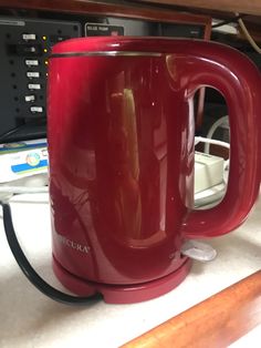 a red coffee mug sitting on top of a counter