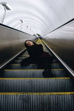 a woman is laying on an escalator