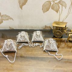 four silver purses sitting on top of a wooden table