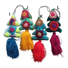 several colorful crocheted ornaments are hanging from strings with tassels on them