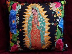 a decorative pillow with an image of the virgin mary on it's front and sides