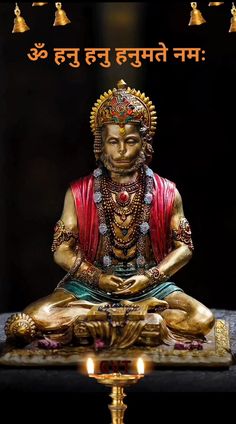 a golden buddha statue sitting on top of a table next to some gold bell lights