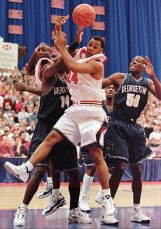 the basketball players are trying to block the ball from being blocked by two opposing teams