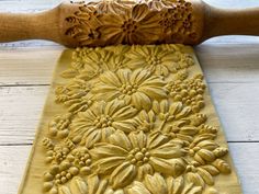 a wooden rolling pin with flowers carved on it