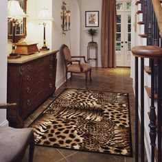 a leopard print rug is on the floor next to a dresser and chair in an entryway