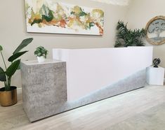 a concrete counter with two planters on the side and a painting hanging above it