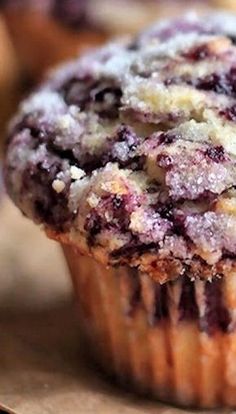 a blueberry muffin with powdered sugar on top is sitting on a table