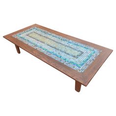 a wooden table with blue and yellow tiles on it's top, against a white background