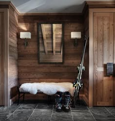 there is a bench in the room with skis on it and snowboards leaning against the wall