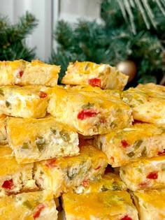 a pile of food sitting on top of a table next to a christmas tree in the background