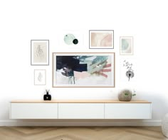 a white entertainment center with art on the wall