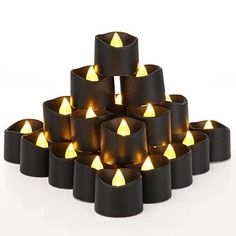 a bunch of lit candles sitting in a pyramid shape