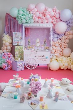 an ice cream cart decorated with balloons and confetti for a baby's first birthday party