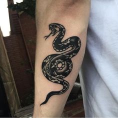 a black and white snake tattoo on the arm